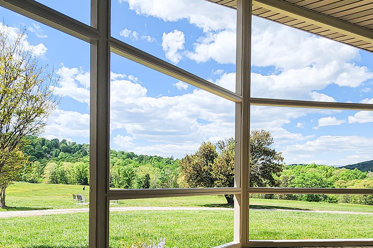 Freshly painted exterior window trim overlooking a grassy landscape