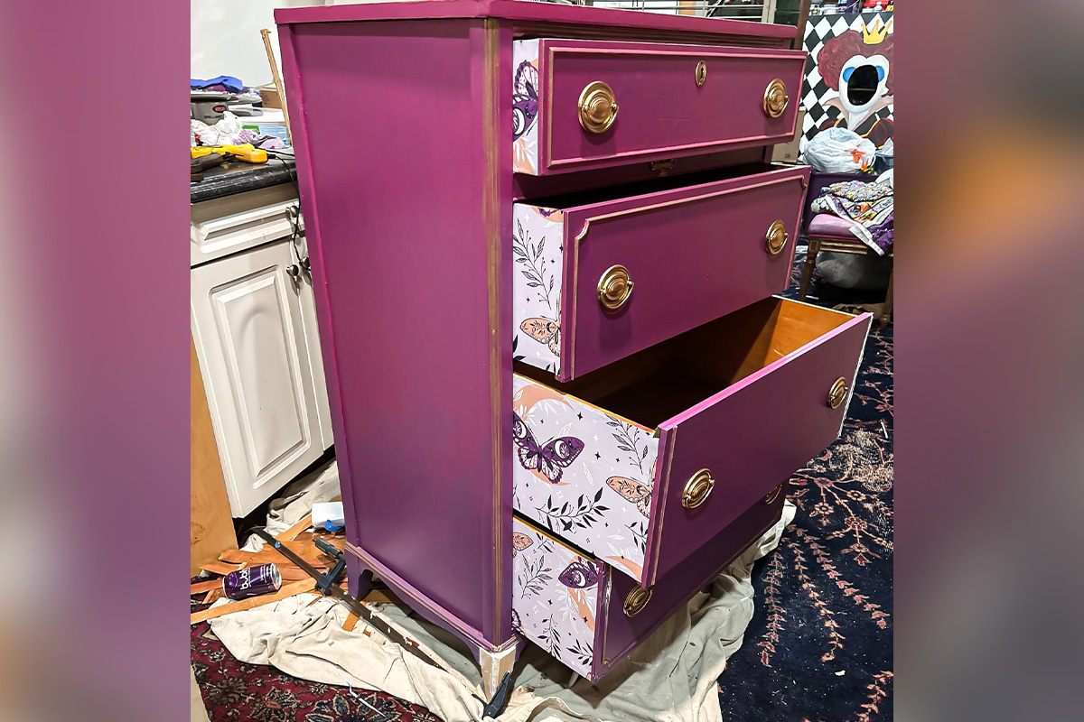 Refinished dresser painted purple with decorative patterned drawer interiors