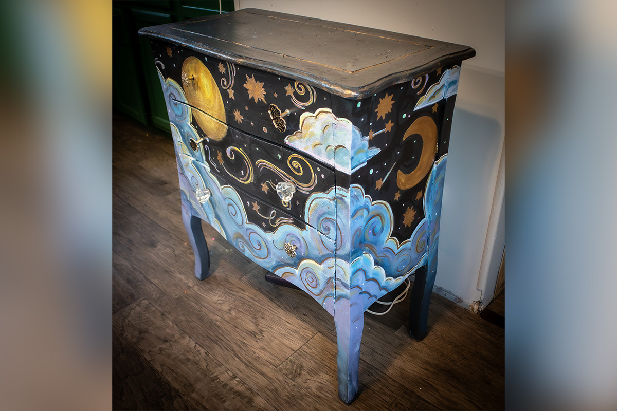 Hand-painted dresser featuring a night sky design with moons, stars, and clouds