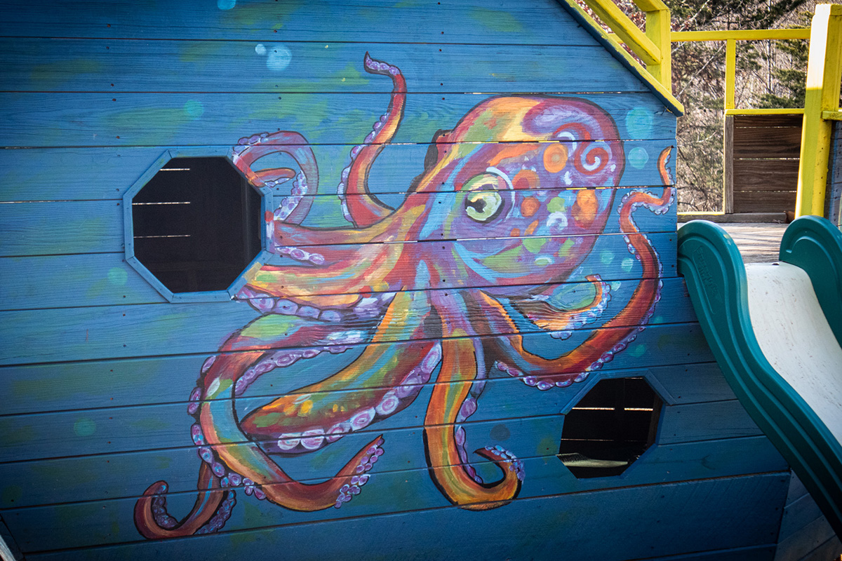 Colorful octopus mural painted on a wooden play structure pirate ship