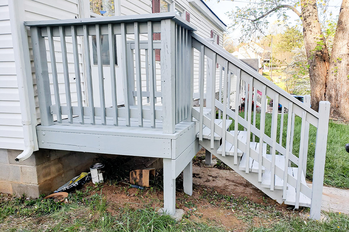 Freshly painted exterior deck and stair railing attached to a home