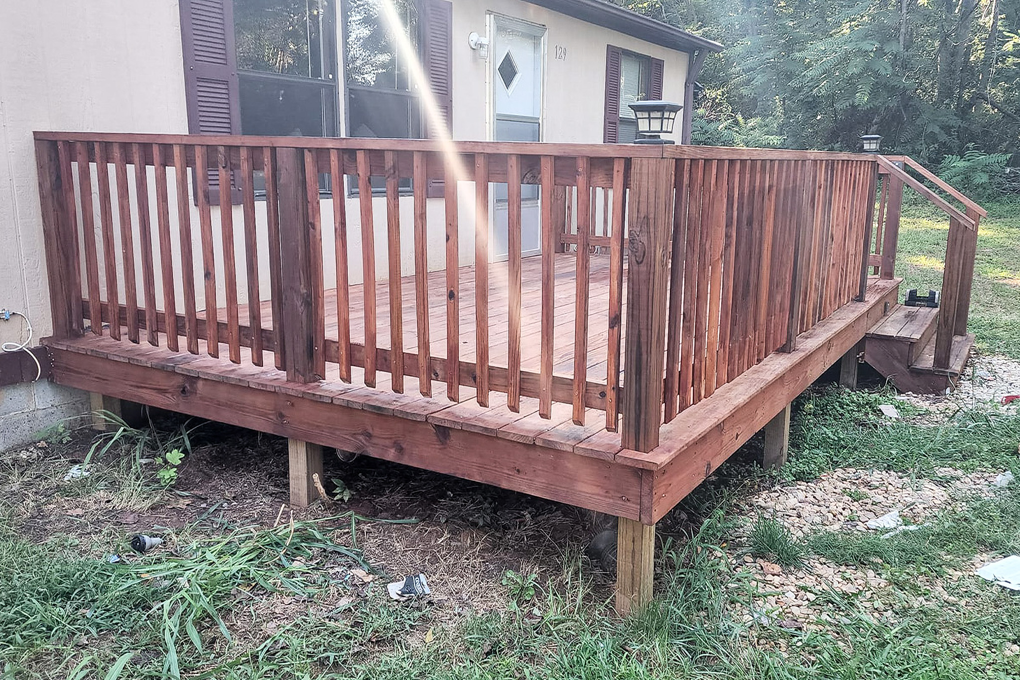 Freshly stained wooden deck with railing attached to a residential home